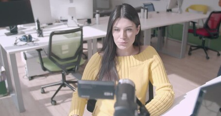 Young female vlogger recording in the office