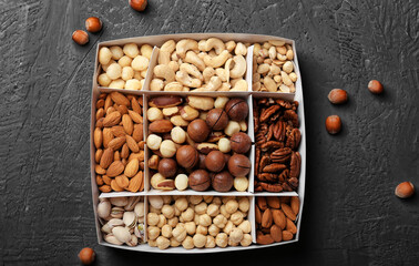 Different grade of nuts in a box on a wooden background top view