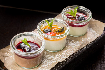 assorted panna cotta with jam decorated with fruit
