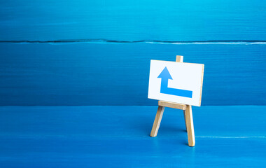 Easel with a blue left arrow. Minimalism. Direction to go around on the left. Advertising. Navigation, customer acquisition. Obscure obstacles, move towards the goal. New rules. Copy space