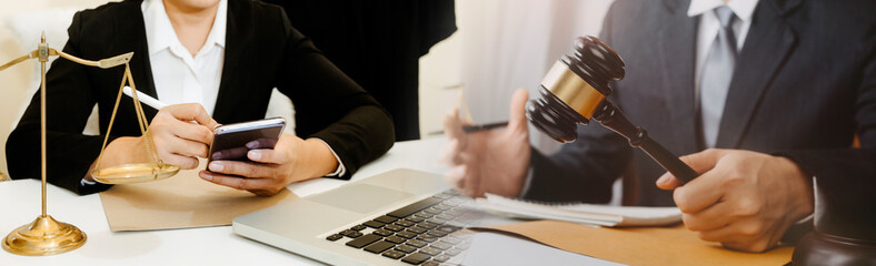 Business and lawyers discussing contract papers with brass scale on desk in office. Law, legal services, advice, justice and law concept picture with film grain effect