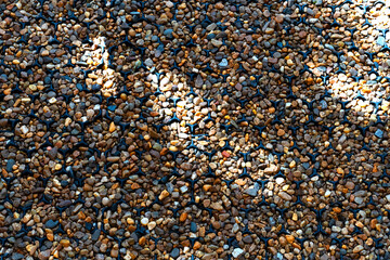 Background of the small rocks walk way with the light and shadow as solid pebble in the garden backyard