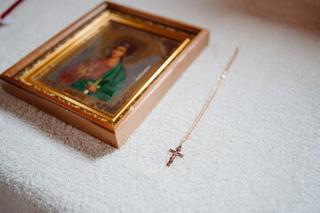 golden cross on the chain and Christian icon. Orthodox baptism.