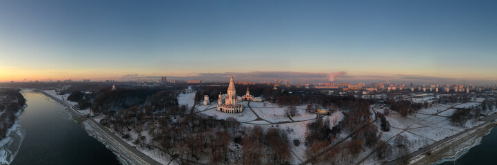 Obraz premium panoramic view of the park in the city on the river bank with old buildings at sunrise in winter filmed from a drone