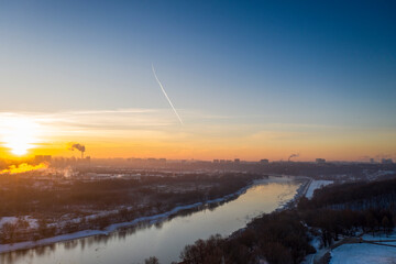 panoramic view of the park in the city on the river bank with old buildings at sunrise in winter filmed from a drone