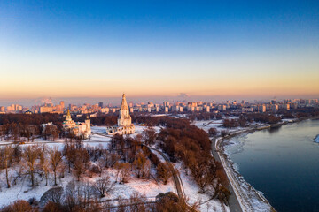 Fototapeta na wymiar panoramic view of the park in the city on the river bank with old buildings at sunrise in winter filmed from a drone