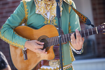 Stringed musical instrument acoustic guitar in the hands of a male musician.