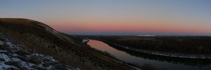 Panoramic view of the river from the cliff. Evening sky after sunset.