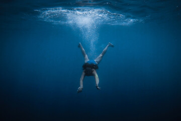 Obraz na płótnie Canvas girl dives into the blue water