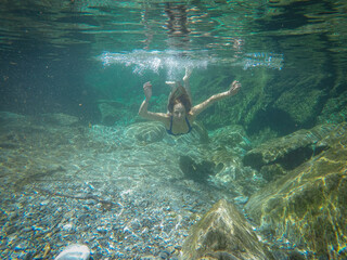 girl swims in the crystal clear green water
