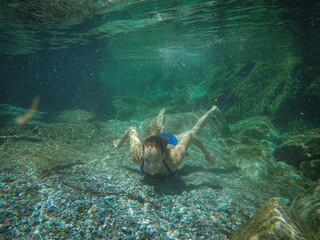 girl swims in the crystal clear green water