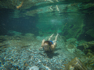 Fototapeta na wymiar girl swims in the crystal clear green water