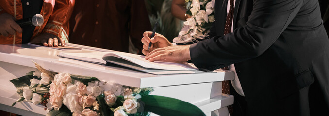 Husband and wife signing the marriage book. Married couple. Signing male. Husband and wife signing...
