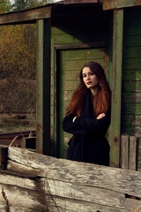 Portrait of a girl in a black coat. A girl in a black coat is standing on the porch.