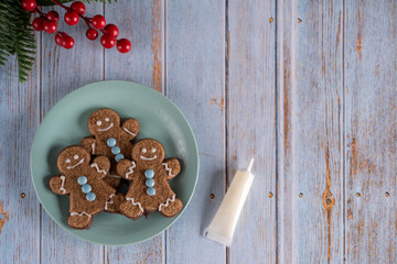 Christmas gingerbread men cookies on a blue plate on a wooden background