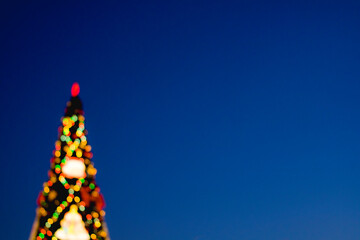 Christmas tree in blurred focus. Bokeh balls of different colors.