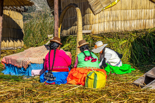 Peru, Lake Titicaca, Daily life of the URO people living on floating islands. Women sitting on the floating reef floor.
