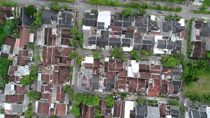 Aerial image of a densely populated housing. A small housing that is very tightly located and neat, accompanied by green trees that grow fresh around it. Cool atmosphere at home to residents.