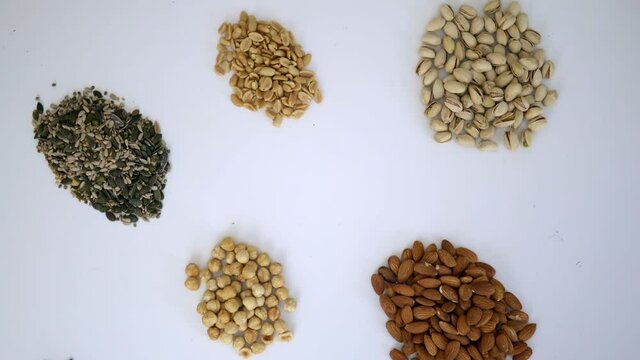 Groups of nuts and seeds on a white table