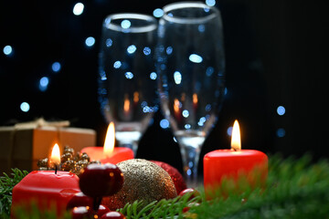 Lighted red candles surrounded by holiday decorations.