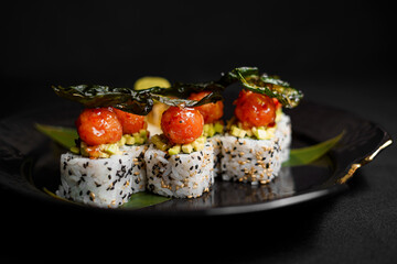 Sushi on a black art plate and black background