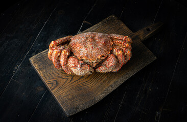 Chinese mitten crab on a cutting board. Shanghai hairy crab. Wooden background