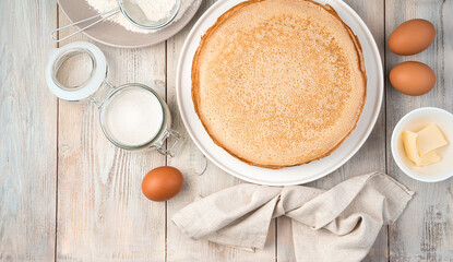 Eggs, sugar, flour, honey and ready-made pancakes with space to copy on a light background. The view from the top. The concept of cooking, Mardi Gras.