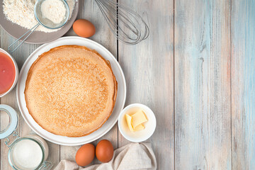 Obraz na płótnie Canvas Plate with pancakes, eggs, flour, butter, honey on a light background. Top view, with space to copy. Concept of cooking, Maslenitsa.