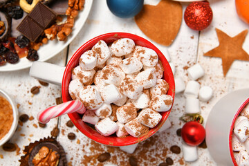 sweet food top view background for merry christmas or new year holiday decoration - chocolate candies, tangerines, cookies, marshmallow and cocoa latte on white wood