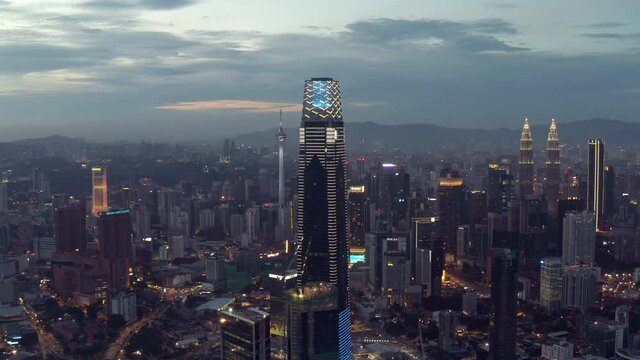 Establishing aerial cinematic drone b-roll shot of sunset at Kuala Lumpur city skyline. 