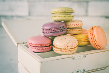 Pastel colored french macarons on a wooden vintage box