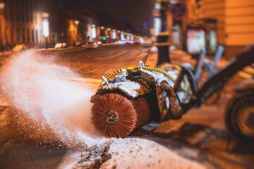 Process of snow removal on the city streets and roads with municipal vehicle, bulldozer, snowblower plow truck, snowplow, snow removal equipment in winter night