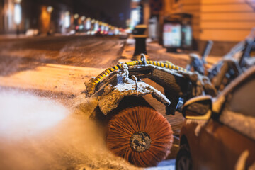 Fototapeta na wymiar Process of snow removal on the city streets and roads with municipal vehicle, bulldozer, snowblower plow truck, snowplow, snow removal equipment in winter night
