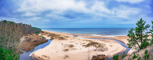 White sand beach and Baltic sea surrounded by conifer trees forest in Baltic. The White Dune and...