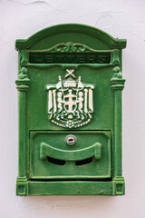 Green metal antique mailbox on a white house wall in old NIcosia, Cyprus