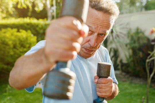 Mature man training with dumbbells