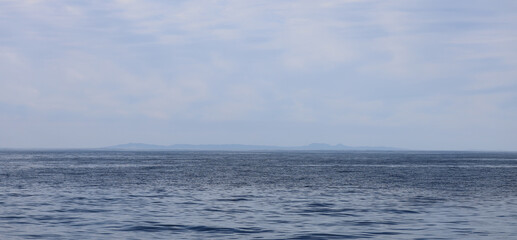 View of Catalina Island from the sea, ocean with clouds.