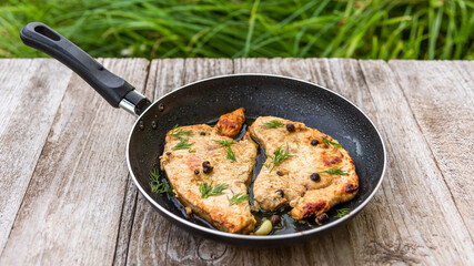Roast Turkey in a frying pan on a wooden table.