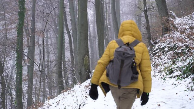 Image of man with yellow jacket walking at trail during the winter, Zagreb.