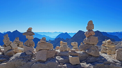 Stein Türmchen Haufen vor Berg Alpen Panorama mit blauem Himmel und Sonne