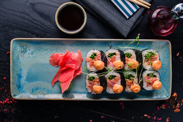 delicious sushi served in Japanese restaurant, sushi with chopsticks on wooden background