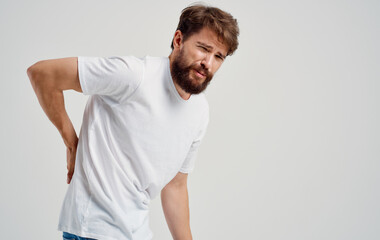 back pain young man in t-shirt beard mustache brunette