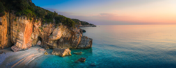 Beautiful Milopotamos beach at Pelion Greece, with arch on sunrise time, wide panorama - 398971563
