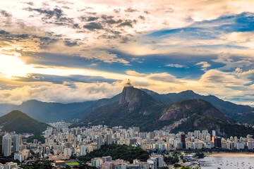 Looking out over Rio de Janiero as the sun sets and clouds surround Christ the Redeemer in the distance.