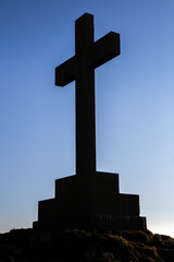 Saint Dwywen's Cross, Llanddwyn Island, Newborough, Anglesey. Large Anglican Christian Victorian memorial cross silhouette against the sky.