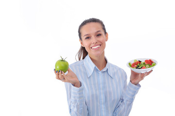 Fototapeta premium Portrait of a beautiful woman doctor holding a plate with fresh vegetables and green apple. Woman doctor