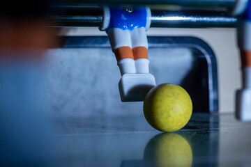 Kicker tisch mit blauer Figur vom Tor mit gelben Ball