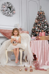 Christmas shooting of a cute little girl in the studio with wings