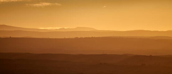 Nice autumn sunset with a cloudy sky over the silhouetted hills