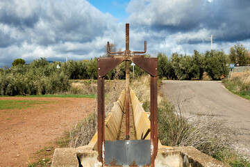 Rusty metal gate system to control the flow of water in an irrigation ditch for crops